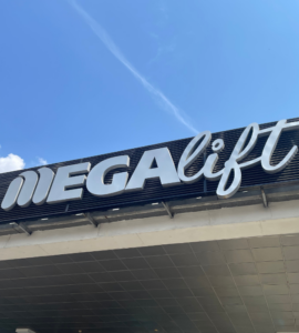 Montacargas eléctrico Megalift transportando carga en almacén industrial, mostrando estabilidad y tecnología eco-amigable para operaciones logísticas sostenibles.