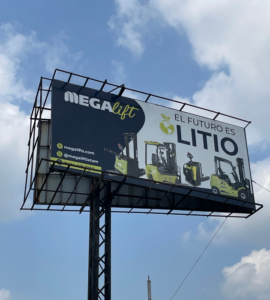 Montacargas eléctrico Megalift operando en almacén con estanterías industriales, mostrando maniobrabilidad y diseño ergonómico para logística eficiente.
